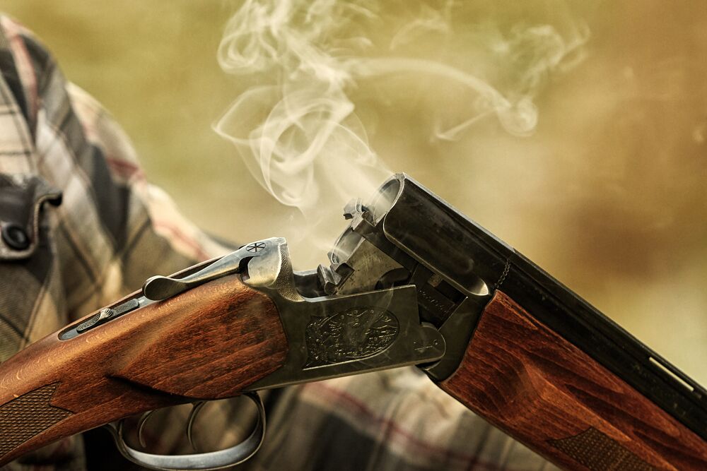 Open shotgun with smoke rising from the barrels