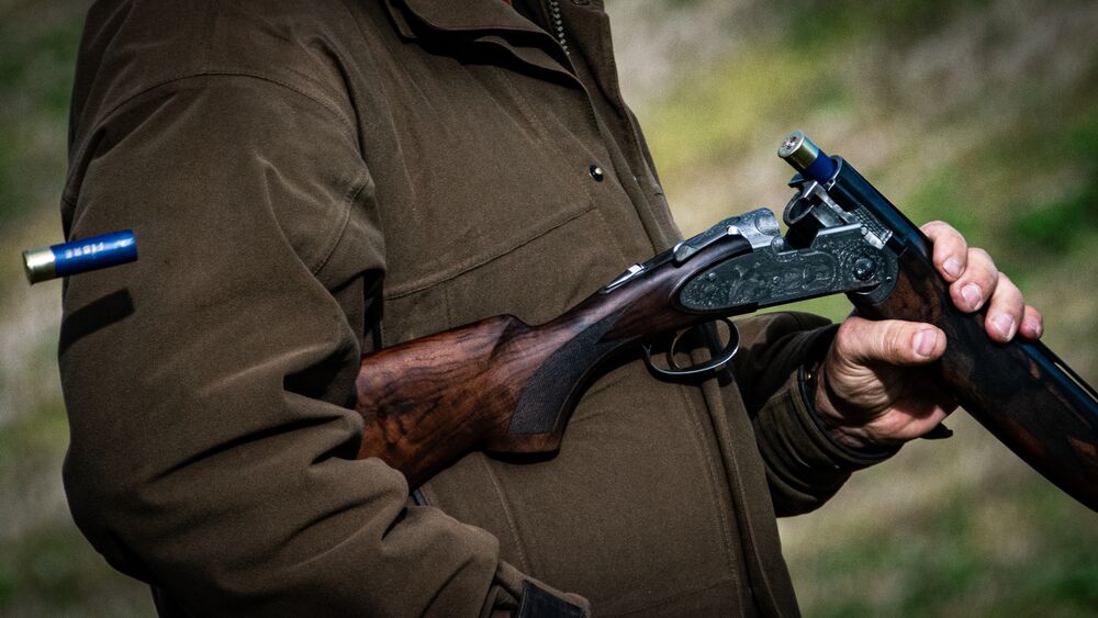Open shotgun ejecting a spent cartridge