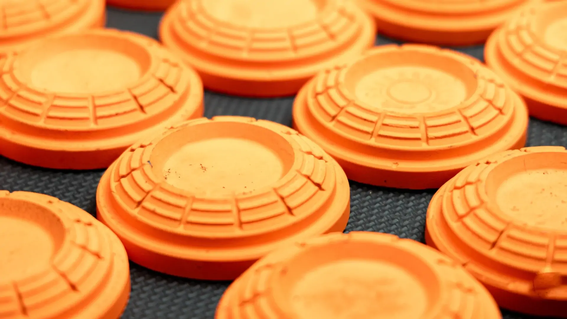 Orange clay pigeons on a dark surface