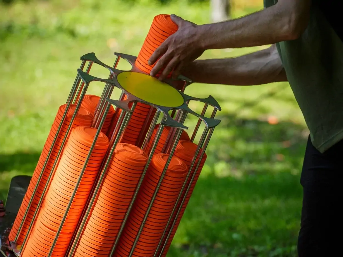 Orange clay pigeons being loaded into a trap machine
