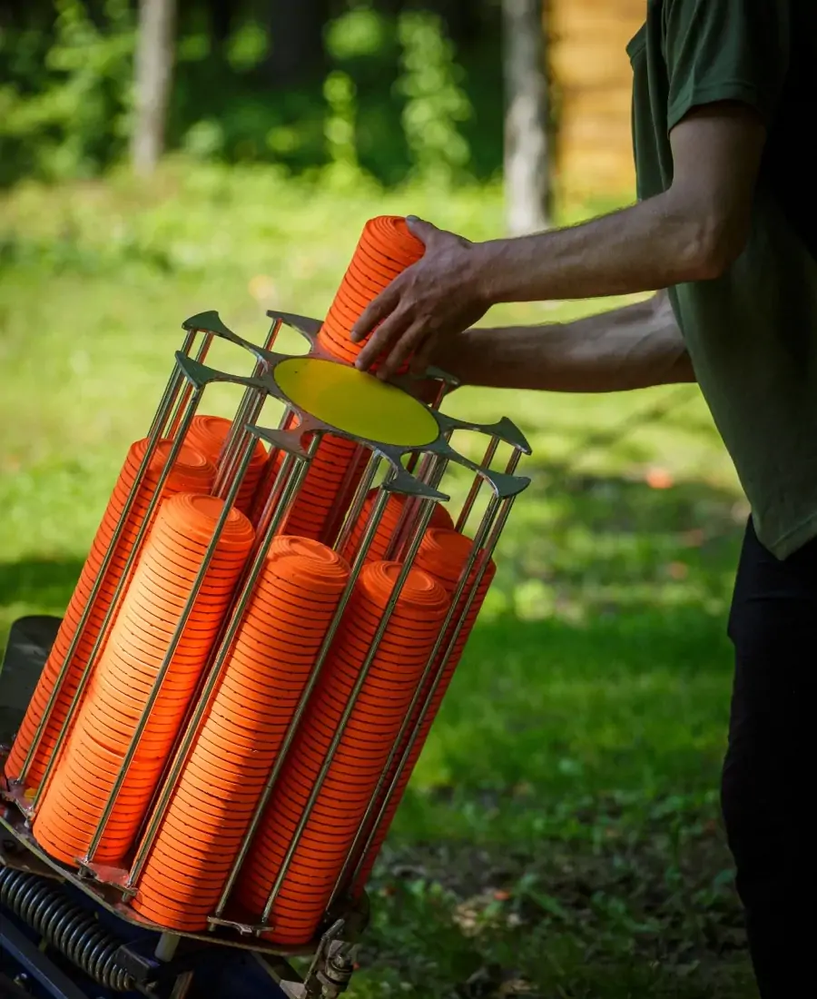 Orange clay pigeons being loaded into a trap machine